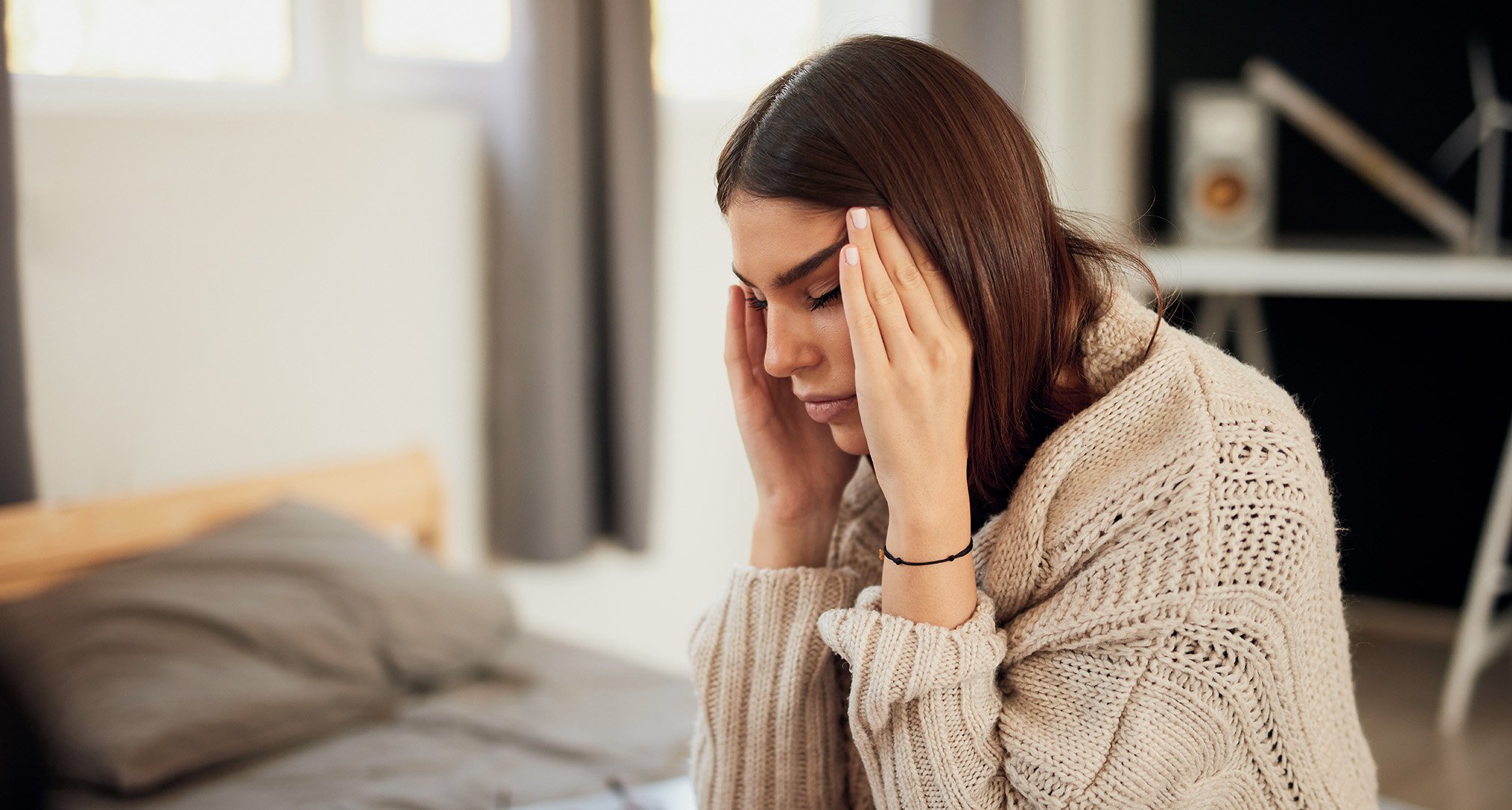 persoon met gesloten ogen die zijn hoofd vasthoudt